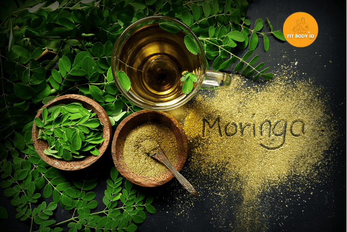 A bowl of vibrant green moringa powder, finely ground and packed with nutrients, displayed alongside dried moringa leaves, representing the health benefits and vitality of this superfood.